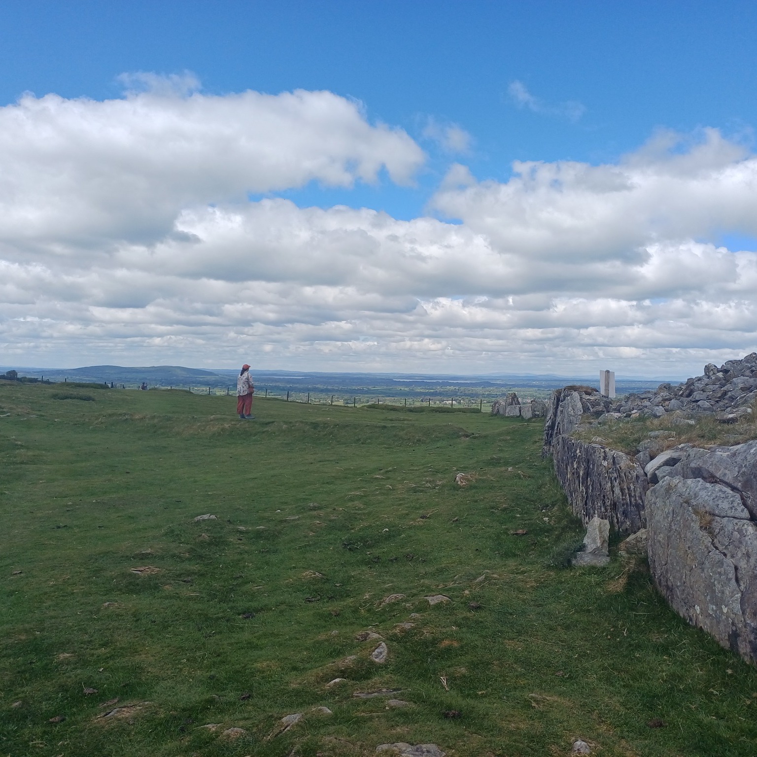 Our tour planner Niamh recently visited Loughcrew while touring the Boyne Valley and it left a lasting impression.
" You would never suspect there is such an amazing monument on the hill behind the modest carpark below.
The climb up to Loughcrew is steep but relatively short and certainly worth it.
The amazing view of the surrounding countryside gives you a great sense of how much family meant to pre-colonial Irish and the efforts that were made to honour loved ones in death.
You can see more impressive megalithic art at the entrance of the remaining tomb, still visible after thousands of years.
Loughcrew was the final stop on my short tour of the Boyne Valley, which is home to an incredible array of ancient tombs and megalithic art, still intact for us to appreciate.
As someone who always felt connected to Celtic Ireland, my weekend in the Boyne Valley encouraged me to look further and deeper, back to neolithic times, thousands of years earlier. These earlier settlers had a rich and vibrant culture, evidence of which remains in our landscape.
These sites are places of pilgrimage for many Irish today. They may be the closest connection we have to the real, pre-colonial Ireland.
For anyone interested in these sites, "Listen to the Land Speak" by the late, great, Manchán Magan is a wonderful introduction and will encourage you to pay more attention to the amazing stories our landscape has to offer.
PS: If visiting, please do not climb on the tombs! You are unfortunately likely to see others doing so! These are burial grounds and have already survived up to 5,000 years! Please respect the monuments so we can preserve them and their stories for future generations."