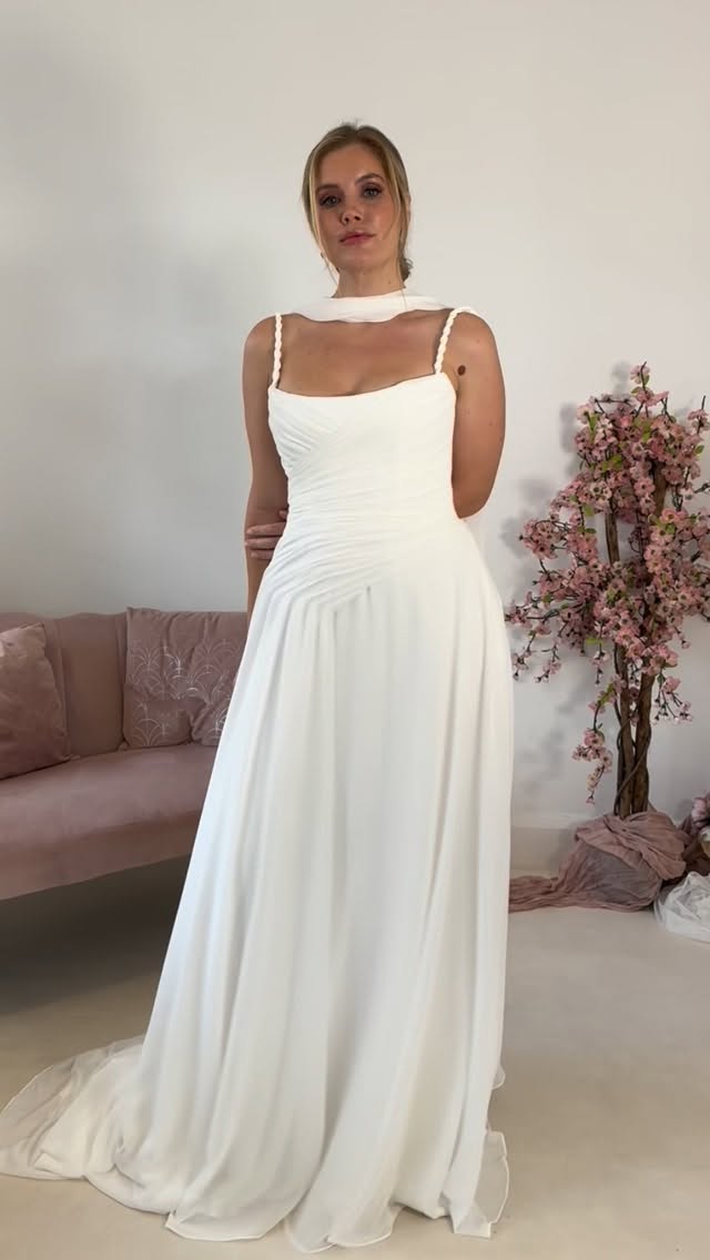 Just in: A closer look at our 2026 bridal collection.
Gown 2 — Say hello to Selina. Sculpted simplicity, soft romance. Designed for the bride who redefines tradition.
.
This stunning square necked chiffon gown features a fully structured corseted base layer, gathered chiffon across the bodice to create an extra cinched appearance to the waist. The pleats extend beyond the hip to fall elegantly into the full A line, semi cathedral length train. The straps are formed of twisted chiffon that frame the neckline perfectly and accentuate the elegant, modern and timeless classic that is the Selina gown. The back corset is fastened with a signature pearl zip puller.
.
Hair & Makeup @dawn.clark_hairandmakeup
Model @sophielawrencemodel
Studio @stormestudios @storme_hmua_education
Dresses @mayandgracebridal by @savannahmillerbridal
.
#bridal2026 #ModernBride #ContemporaryBridal #mayandgracebridal #BridalElegance #MinimalistBride #WeddingStyle #BridalFashion #NewArrival #TimelessDesign #LuxuryBridal #WeddingInspo #sayyestothedress
